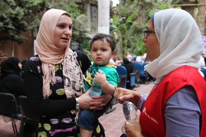 Radwa Khairy, Child Safeguarding Officer, speaks to a Syrian family about their thoughts on the Forsa Project during the community event in Faysal, Greater Cairo.. 